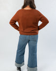 Back view of Bourbon Weather Intarsia Knit Sweater in rich bourbon color, highlighting soft knit texture and classic crew neckline.