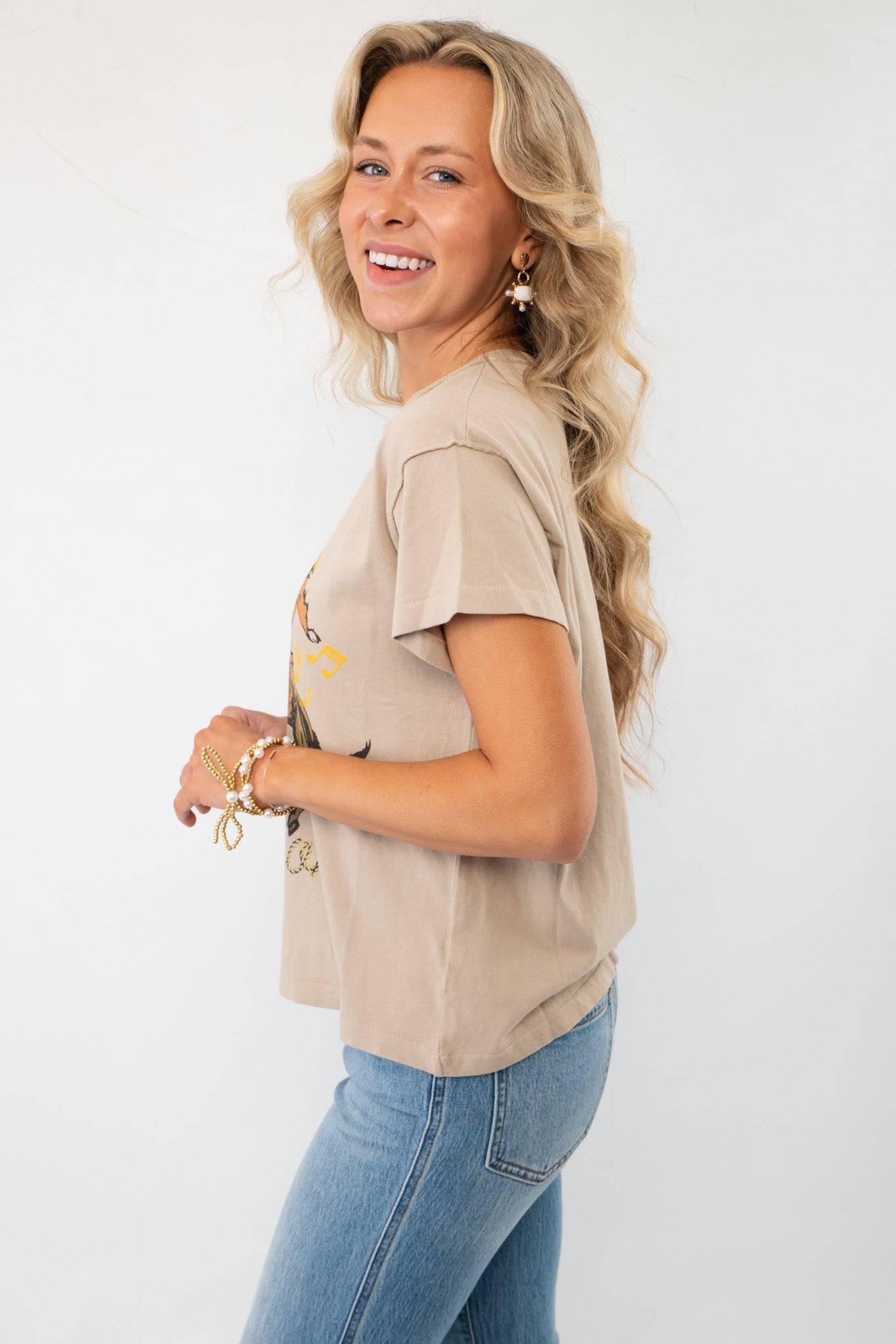 Side view of the Daydreamer Willie Nelson 'A Horse Called Music' Graphic Tee, featuring a relaxed fit and soft beige cotton fabric.