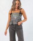 Girly Girl Shiny Black Gingham Peplum Top – Cute & Chic tank top with velvet bows and adjustable straps, styled with wide-leg jeans.