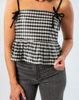 Close-up of Girly Girl Shiny Black Gingham Peplum Top featuring velvet bow details and a flattering cropped peplum hem.