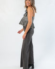Side profile of Girly Girl Shiny Black Gingham Peplum Top showing flared hem and adjustable shoulder straps for a flattering fit.