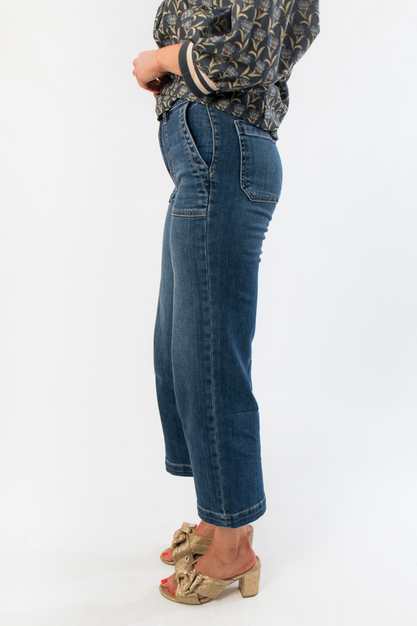 Side view of Kut Charlotte Reflective High Rise Wide Leg Jean highlighting the reflective denim texture and structured pocket design.