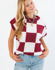 Checkmate Burgundy Sweater Vest with bold burgundy and white checker print, styled sleeveless for perfect fall layering over light tops.