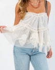 Close-up of Free People Ivory Sweet Escape Cami featuring delicate lace trim, floral embroidery, and sheer tiered tulle peplum detail.