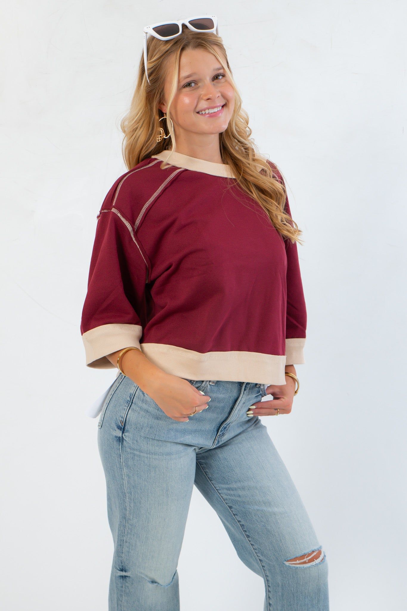 Close-up of Vickie Sweatshirt showing burgundy body with cream trim and exposed seam details for a trendy, laid-back look.