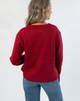 Back view of Game Day Garnet Knit Sweater showcasing solid maroon knit and ribbed detailing on hem and cuffs.