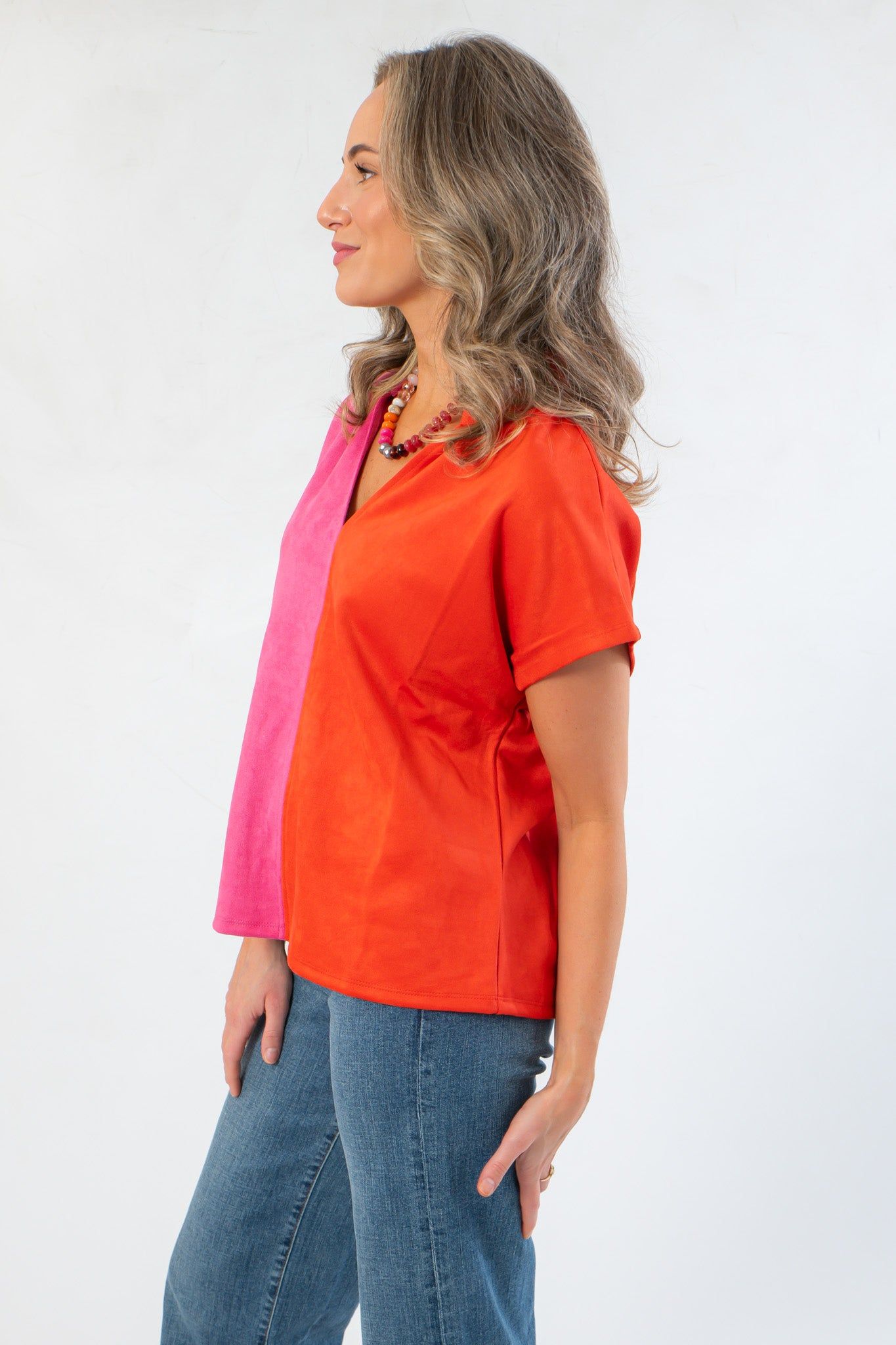 Side profile of THML Orange & Pink Colorblock Suede Top showing soft suede texture and short sleeve cut for casual elegance.