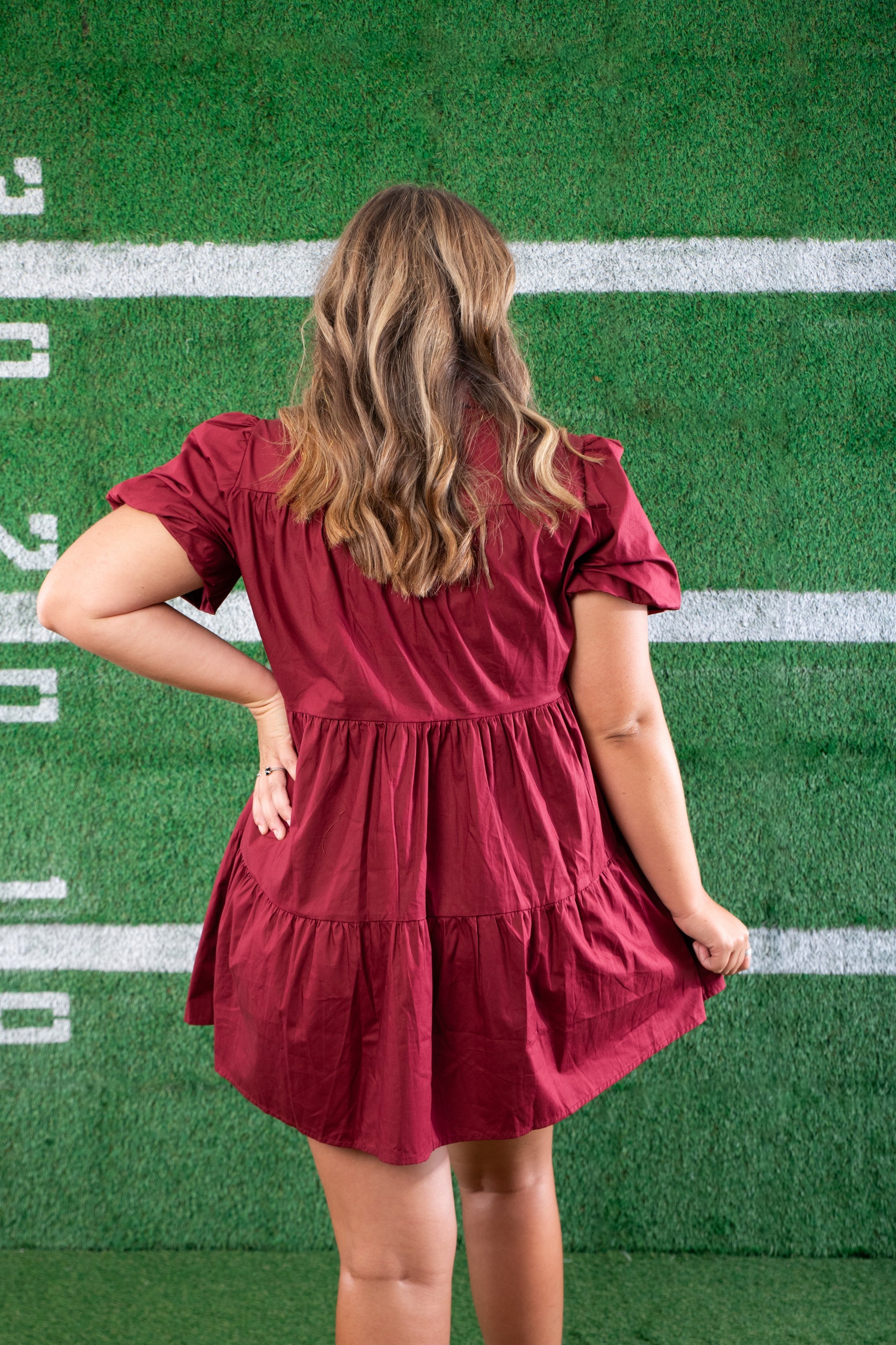 Back view of the Garnet Sequin Football Dress, showcasing its tiered silhouette and puff sleeves. A must-have short dress for stylish football lovers.