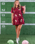 Shine in style with the Garnet Sequin Football Dress, a short-sleeve button-up mini dress featuring sequin football patches. Perfect for game day fashion.