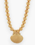 Gold Statement Shell Necklace featuring a bold gold shell pendant on a beaded chain. A luxe beach wear accessory perfect for summer and vacation outfits.