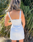 Rear close-up of MinkPink Imogen White Drill Tie Mini Dress showcasing zip closure and structured cotton fabric for a sleek summer look.