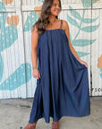 THML Denim Buckle Strap Midi Dress with flowy silhouette and brown buckle straps, styled with ankle boots for a casual fall look.