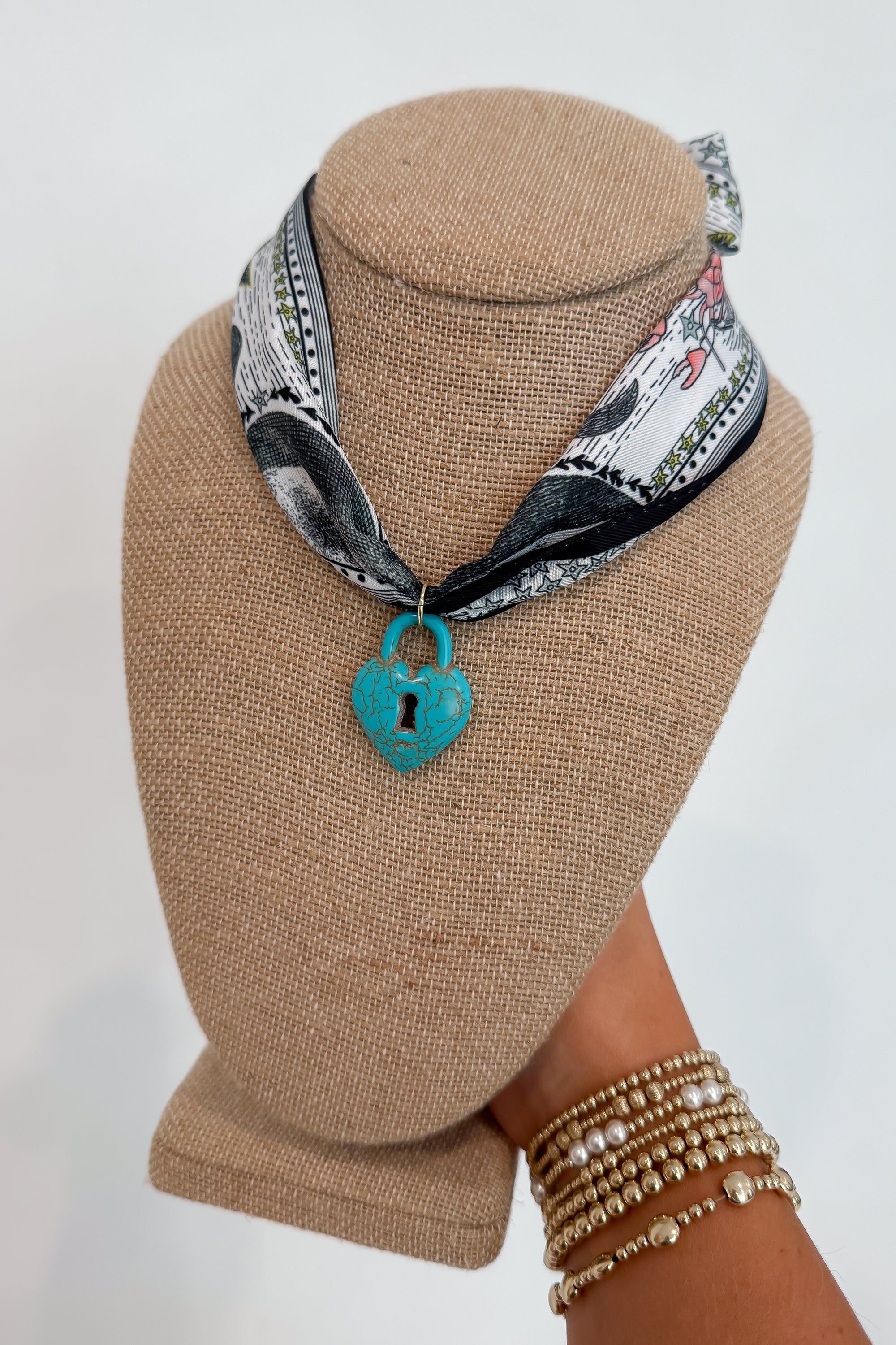Moon Phase Necklace with Turquoise Lock on navy printed bandana scarf, styled on display bust for trendy jewelry accessory appeal.