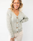 Elegant Liza Mint Cable Knit Cardigan featuring a v-neckline, wooden button closure, and cozy knit texture. Perfect for layering in any season.