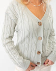 Liza Mint Cable Knit Cardigan with a classic v-neck, button closure, and intricate cable knit design. A stylish layering piece in a soft pastel mint shade.
