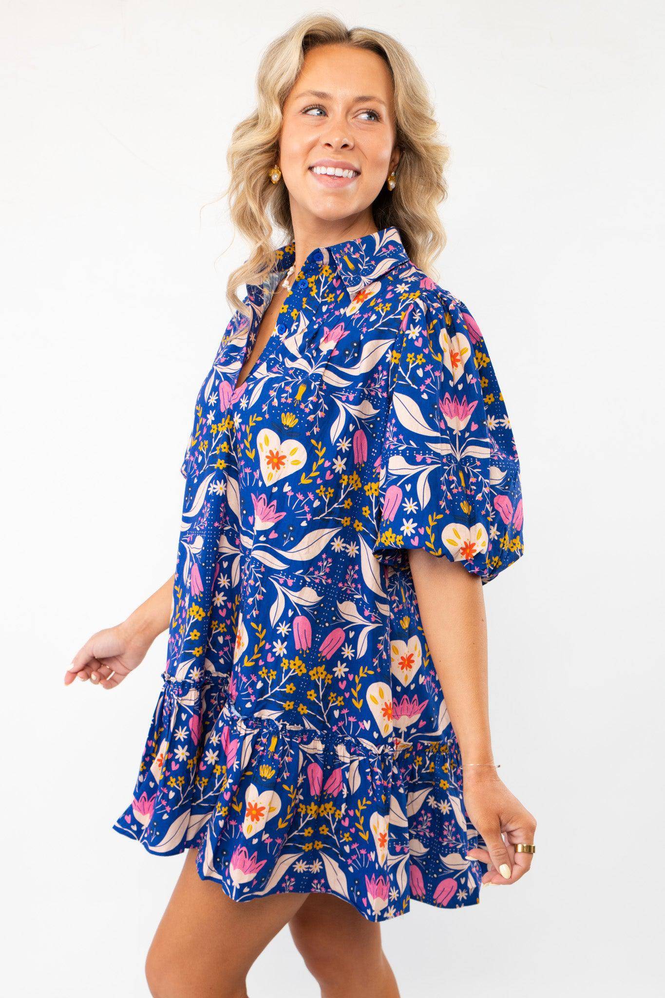 Side view of the Morgan Folk Love Mini Dress highlighting its flowy fit, vibrant print, and playful ruffle hem for a chic casual style.
