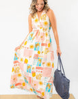 Flowy Moroccan Coast Tile Print V-Neck Maxi Dress styled with a woven tote, featuring a breezy fit and vibrant summer-inspired patterns.