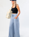 Side view of Free People Soft Chambray Wide-Leg Lounge Pants with flowy silhouette and functional pockets, ideal for stylish lounging.