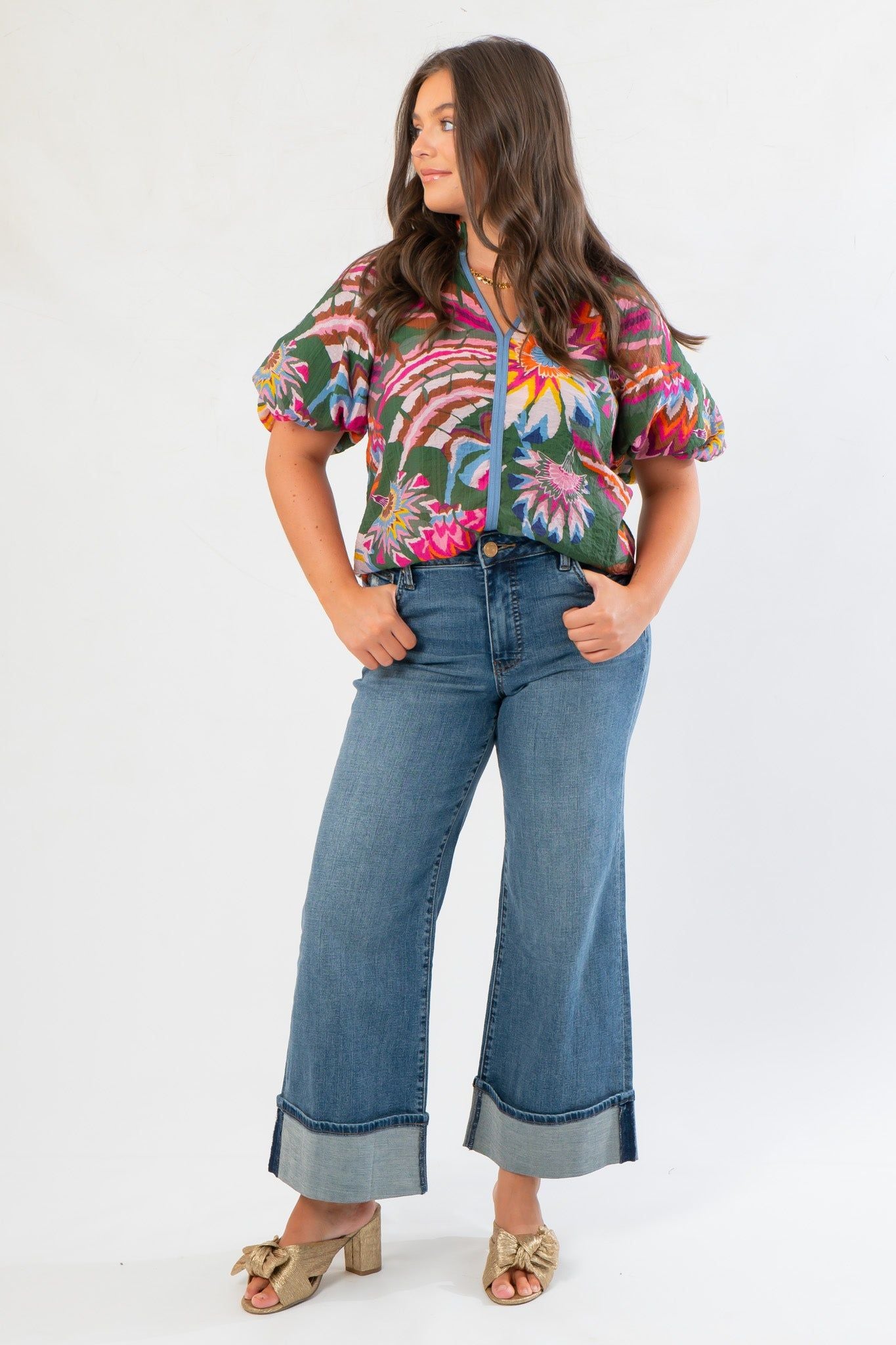 Model wearing THML Printed Puff Sleeve V-Neck Top with hands in pockets, emphasizing the blouse's bold floral print and casual-chic appeal.