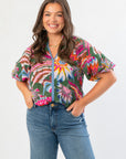 THML Printed Puff Sleeve V-Neck Top in green floral print with short puff sleeves and relaxed fit, styled with high-waisted jeans. Ideal for casual wear.