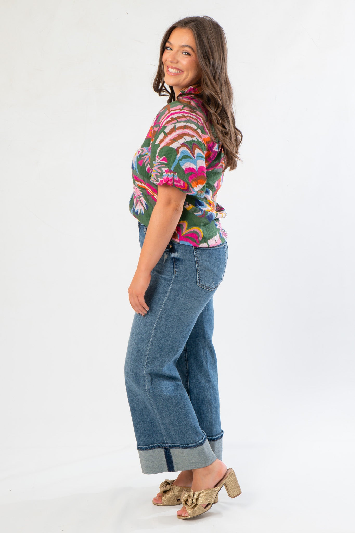 Side view of THML Printed Puff Sleeve V-Neck Top showcasing vibrant floral pattern and puff sleeve detail, paired with wide-leg cuffed jeans.