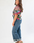 Side view of THML Printed Puff Sleeve V-Neck Top showcasing vibrant floral pattern and puff sleeve detail, paired with wide-leg cuffed jeans.