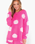 Model wearing the Show Me Your Mumu Hot Pink Shell Go To Sweater, styled with matching shorts. A cozy and stylish pick for vacations and breezy evenings.