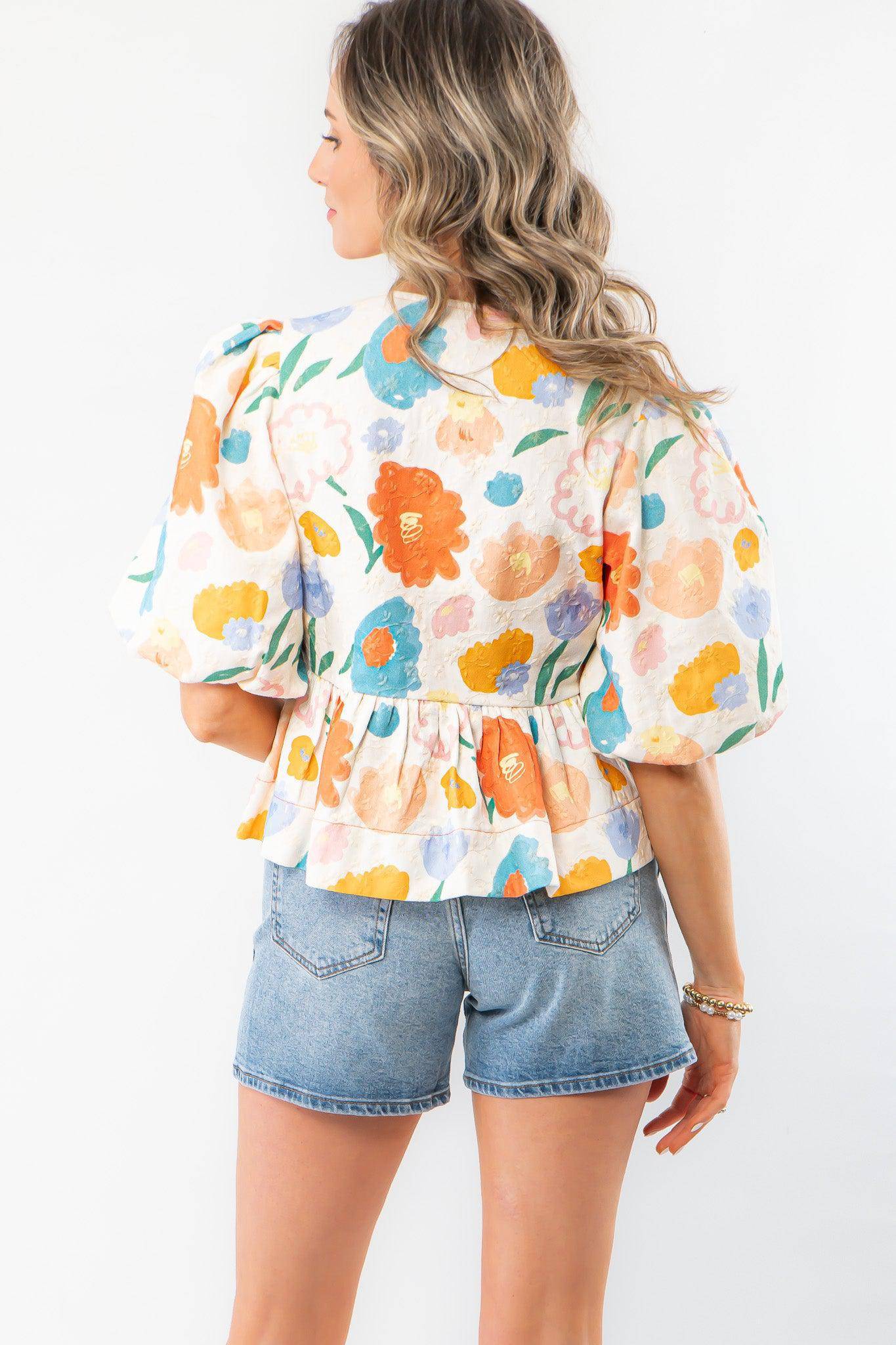 Back view of the Spring Floral Tie-Front Top highlighting its colorful floral pattern, gathered waist, and lightweight fabric for a breezy spring look.