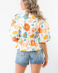 Back view of the Spring Floral Tie-Front Top highlighting its colorful floral pattern, gathered waist, and lightweight fabric for a breezy spring look.