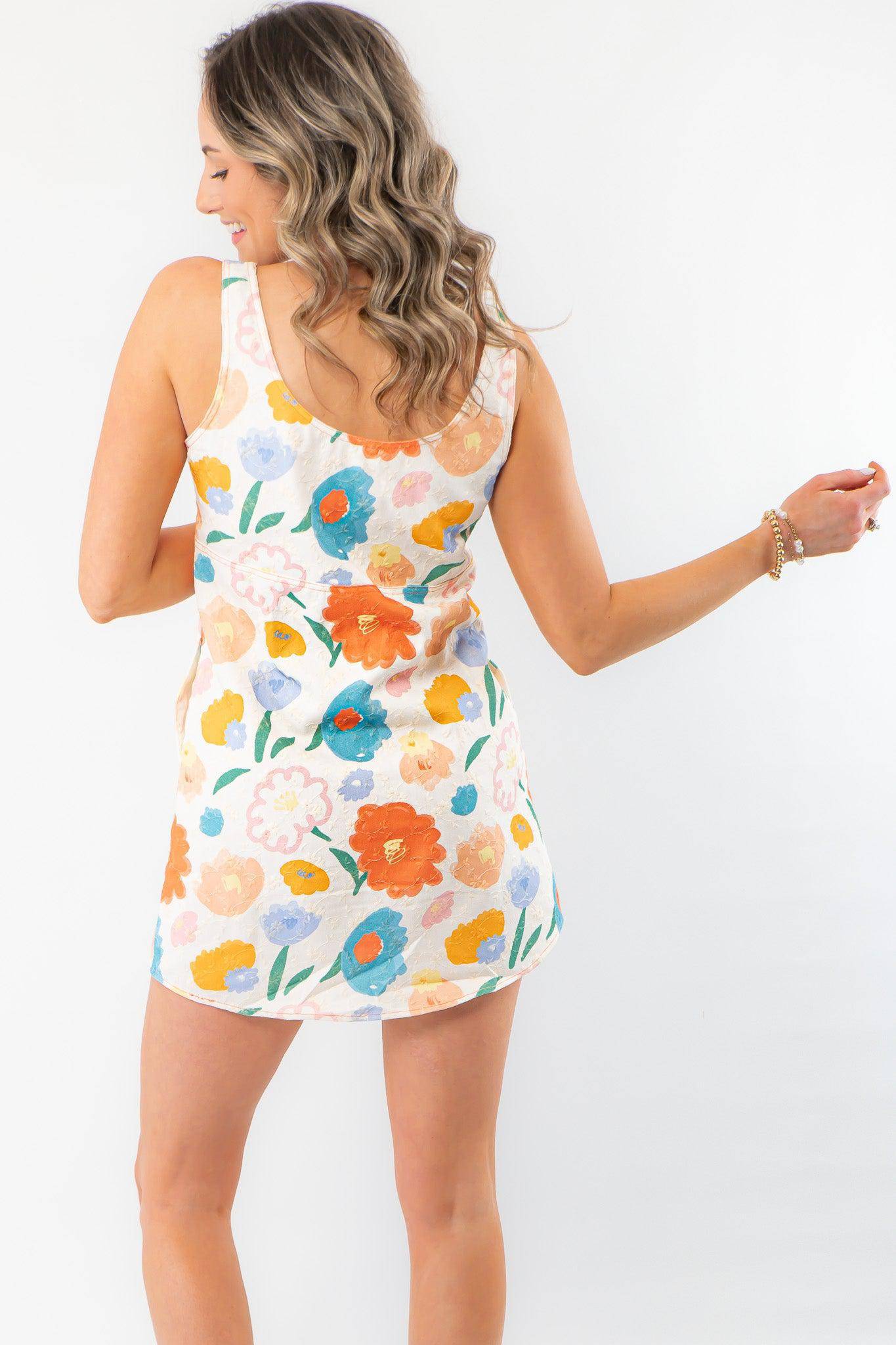Back view of the Spring Multi-Floral Mini Dress highlighting its sleeveless cut, scoop back, and vibrant floral print for a stylish spring look.