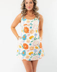 Model wearing the Spring Multi-Floral Mini Dress with pockets, a scoop neckline, and a colorful floral design, ideal for warm-weather styling.