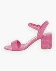 Side view of pink raffia block heel sandals featuring a woven raffia heel and sleek ankle strap for a stylish summer look.