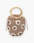 Perfect Picnic Tan Straw Bucket Floral Handbag with white daisy embellishments and circular wicker handles, ideal for summer boho outfits.
