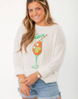 Show Me Your Mumu Ciao Cocktail Woodsy Sweater with colorful cocktail graphic, styled with denim shorts for a casual chic look.