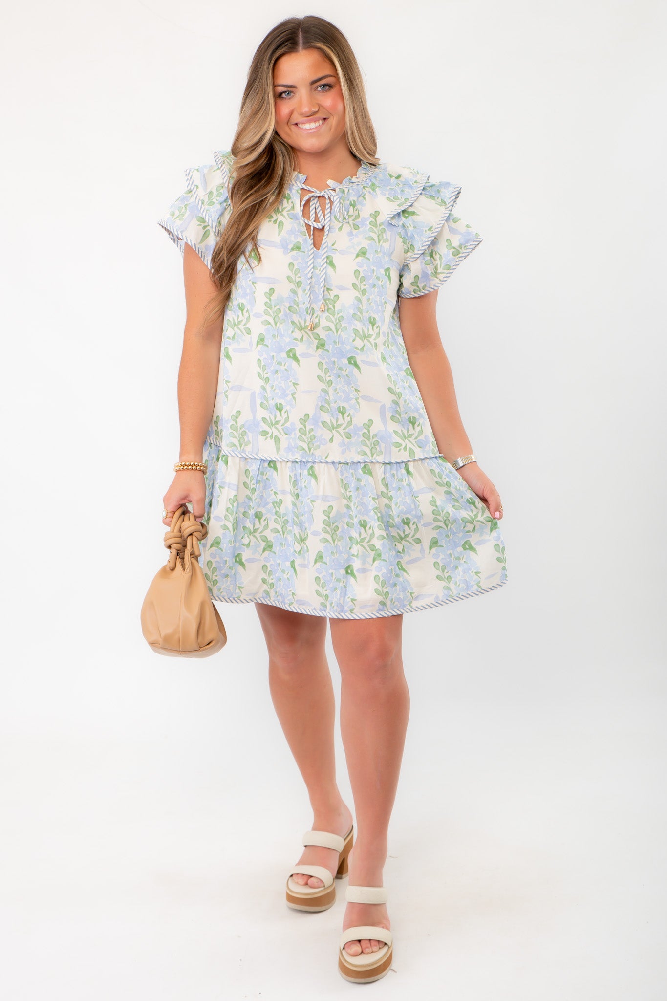 Enchanting Blue Hydrangea Flutter Sleeve Mini Dress for Summer featuring a tiered skirt and floral print, styled with neutral accessories.