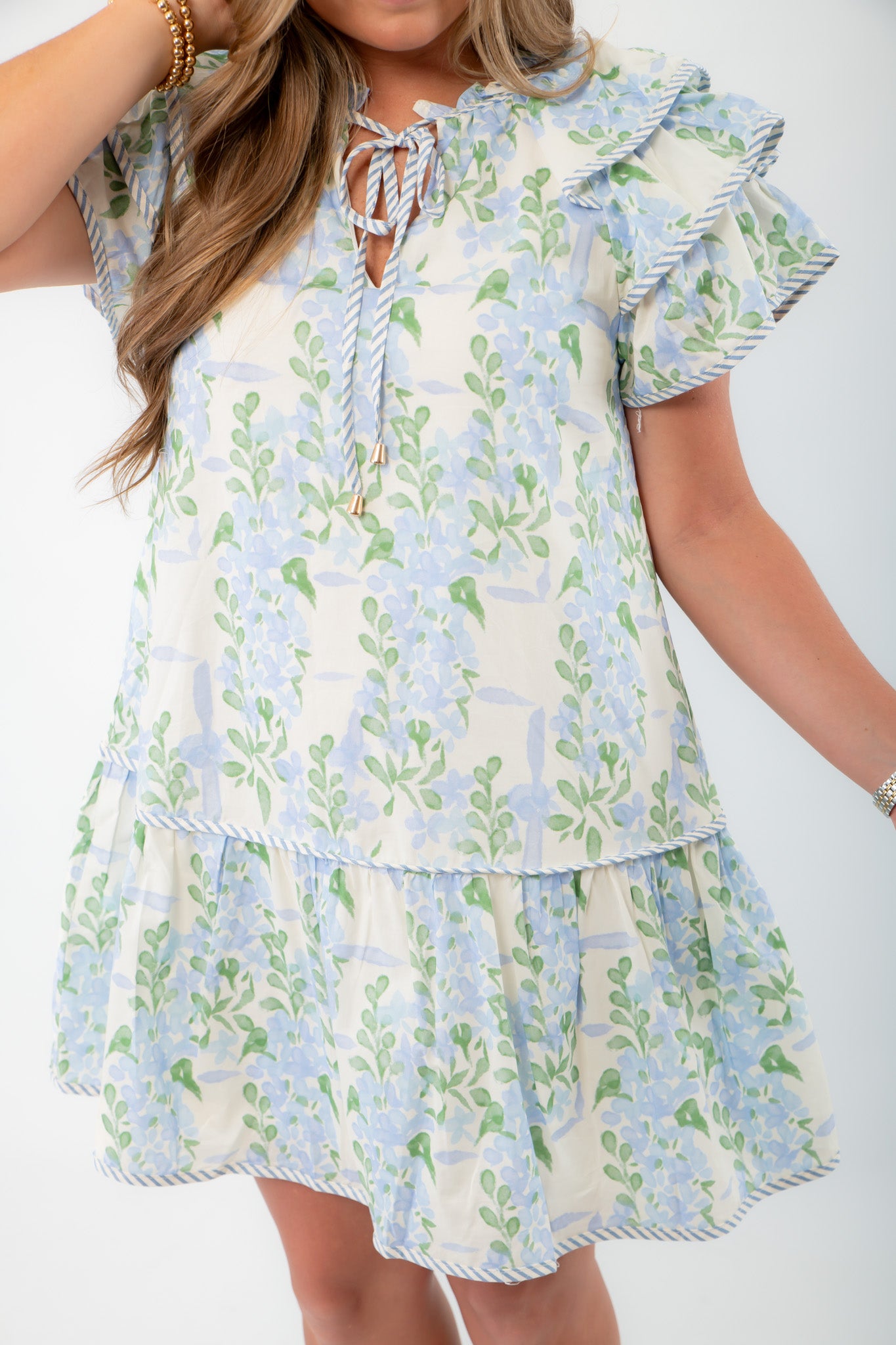 Close-up of Blue Hydrangea Flutter Sleeve Mini Dress highlighting the delicate floral print, striped trim, and ruffle details.