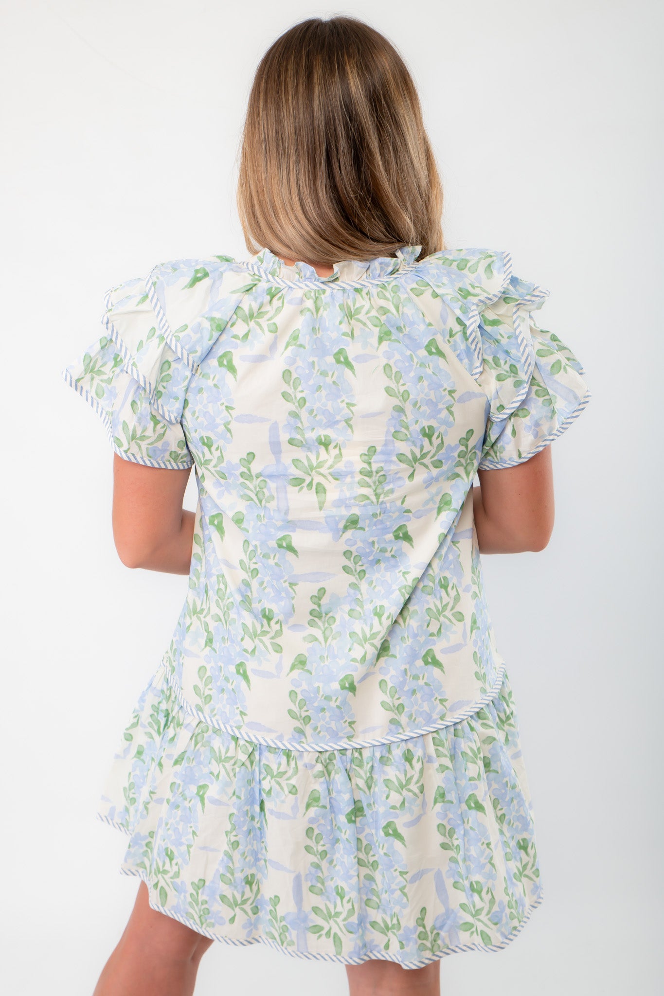 Back view of Blue Hydrangea Flutter Sleeve Mini Dress displaying floral pattern and flutter sleeve design for a feminine touch.