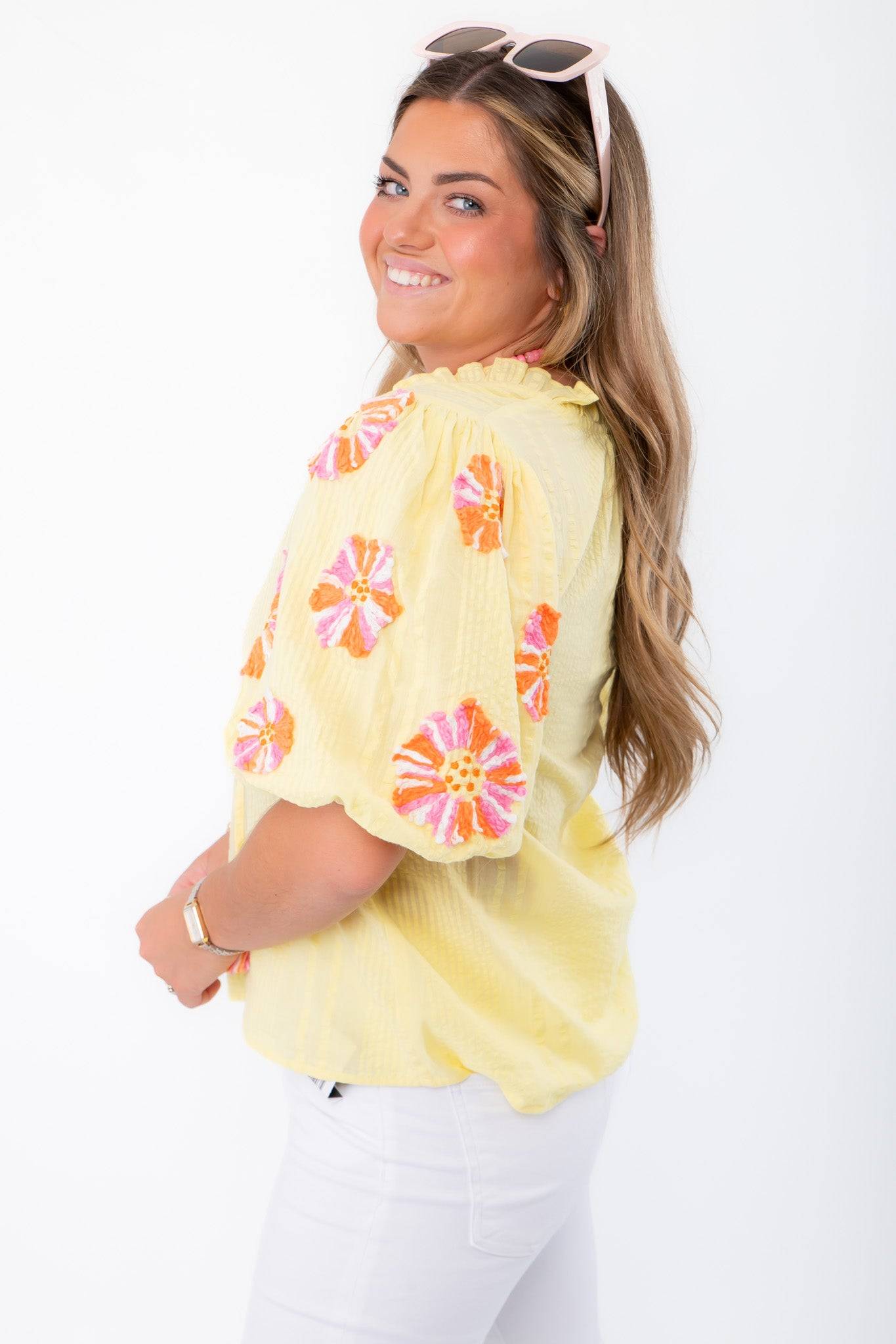 Side view of THML Yellow Floral Pom Blouse showing puff sleeves with floral embroidery and relaxed fit for casual elegance.