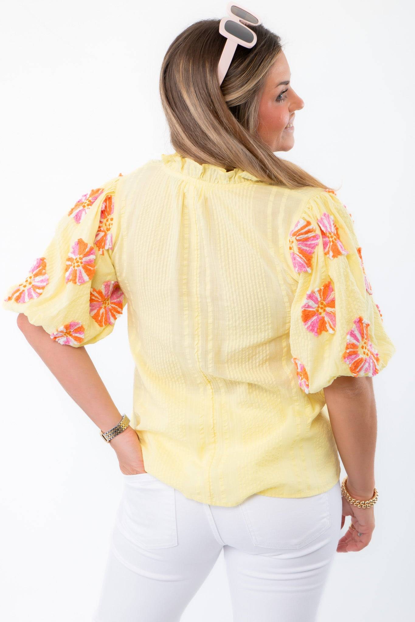 Rear angle of THML Yellow Floral Pom Blouse showcasing textured yellow fabric and embroidered floral puff sleeves for spring style.