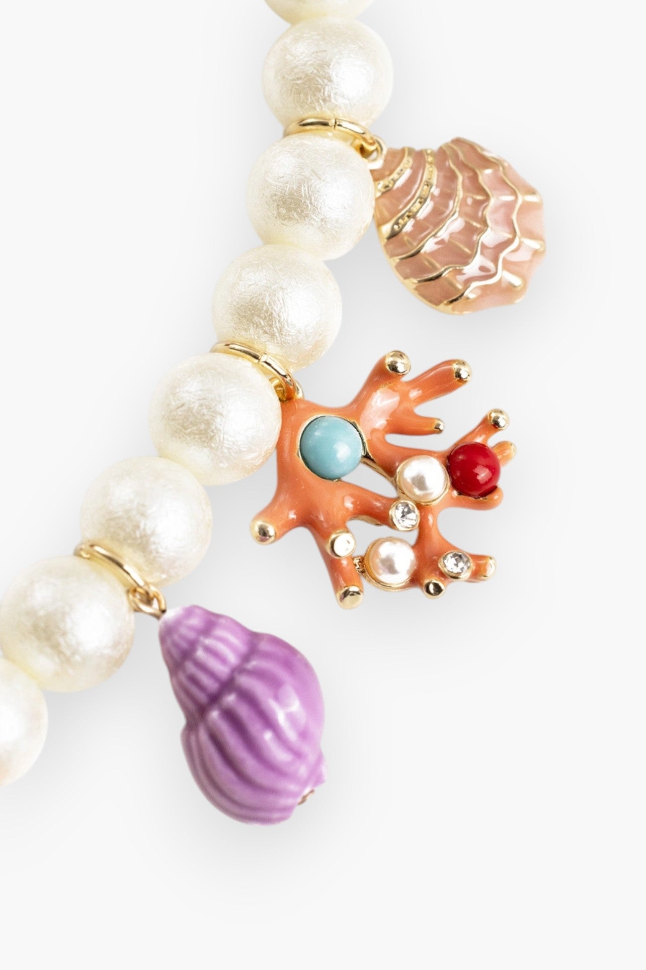 Close-up of Colorful Sea Life Charm Pearl Necklace highlighting coral, shell, and purple conch charms with pearl and gem accents.
