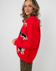 Side profile of Lucy Red Dog Button Up Cardigan showcasing detailed dog motifs on soft red knit, perfect for casual and warm winter outfits.
