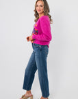 Side view of Bloom Again Floral Magenta Sweater showcasing relaxed fit and soft knit texture, styled with casual denim and heeled sandals.