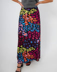 Neon Prowl Animal Print Silky Skirt with colorful cheetah pattern in a flowy maxi length, styled with black heels for a bold look.