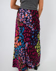 Back view of Neon Prowl Animal Print Silky Skirt highlighting the smooth fit and colorful animal print design on a maxi silhouette.