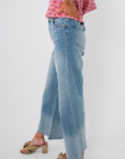 Side view of Kut Generosity Ryan High Rise Super Wide Leg Jean showing wide leg silhouette and raw hem in a soft light wash denim.