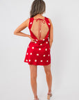 Back view of Cherry Cola Polka Dot Mini Dress with open back and tie closure, combining elegance and fun for stylish summer or bachelorette outfits.