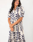Close-up of Harmony Navy & Cream Puff Sleeve Collared Midi Dress showing puff sleeves, collared neckline, and navy leaf pattern on cream fabric.