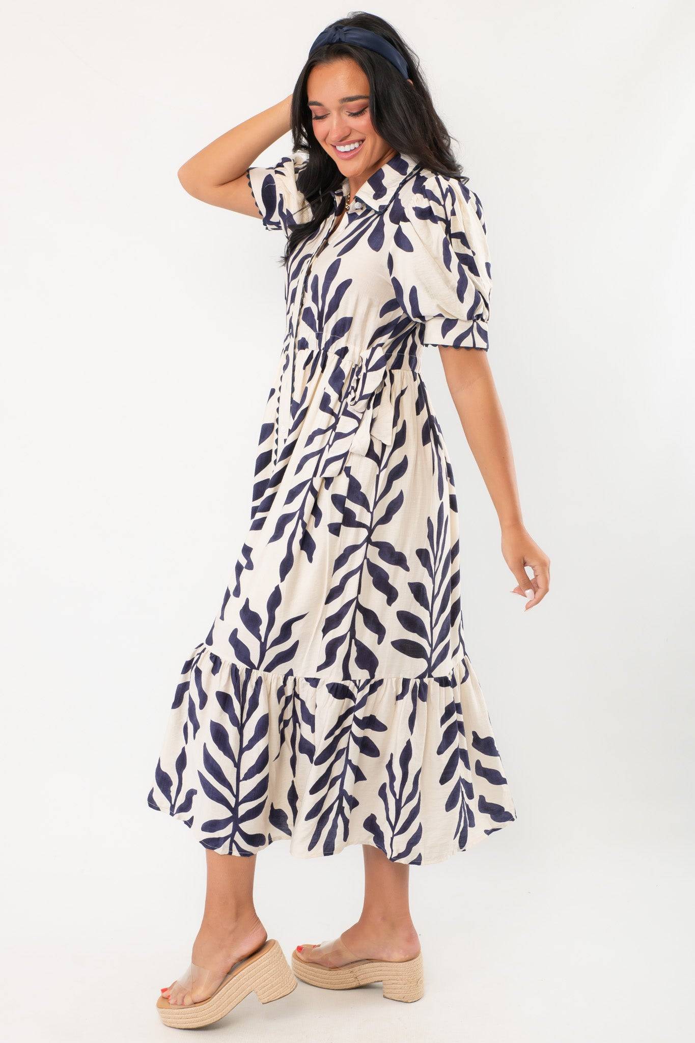 Side view of Harmony Navy & Cream Puff Sleeve Collared Midi Dress highlighting flowy fit, puff sleeves, and navy leaf print on cream background.