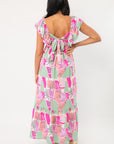 Back view of THML Pink Palm Ruffle Sleeve Maxi Dress showcasing tie-back detail and deep V-cut, ideal for garden parties or beach getaways.