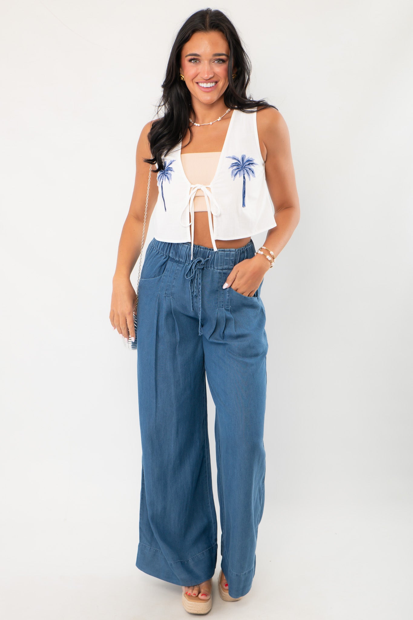 Full outfit with MinkPink Isadora Embroidered Top styled with high-waisted blue pants, a chic boho vacation ensemble.